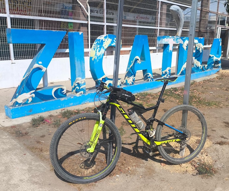 Una bicicleta de montaña frente las letras ZICATELA por de Mercado Zicatela.